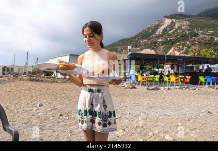 Serveur féminin turc avec sandwich de poisson au restaurant de bord de mer à Cevlik bord de mer Hatay Turquie Banque D'Images