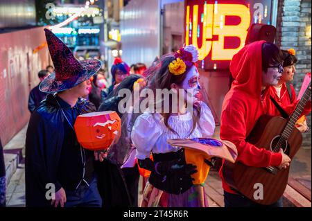 Séoul, Corée du Sud. 28 octobre 2023. Un groupe porte des costumes et joue de la musique dans le quartier nocturne d'Itaewon à Séoul le 28 octobre 2023, un an après un coup de foudre pendant les festivités d'Halloween qui ont fait 159 morts. Les symboles d'Halloween étaient rares à la veille de l'anniversaire, mais certains ont choisi de se déguiser et de célébrer comme une commémoration. Photo de Thomas Maresca/UPI crédit : UPI/Alamy Live News Banque D'Images