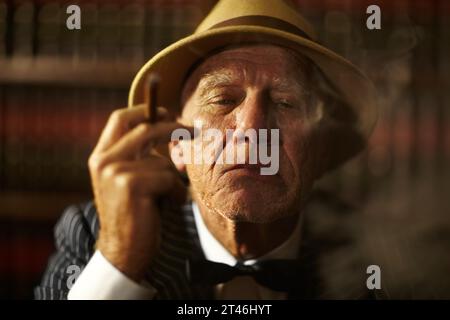 Vieil homme, fumant et portrait dans le bureau avec cigare, fumée et crime patron de mob avec une décision. Penser, visage et gangster senior avec cigarette dedans Banque D'Images