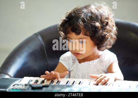 Jeu de musique de fille, d'enfant et de clavier pour l'apprentissage de l'enfance, le développement de l'éducation ou des leçons. Personne féminine, enfant et piano touches chanson ou instrument Banque D'Images