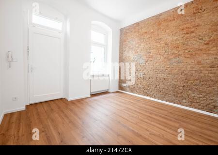 bureau ou appartement vide ; chambre avec mur de briques et plancher en bois Banque D'Images