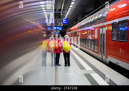 Berlin, Allemagne. 29 octobre 2023. Les passagers se tiennent à côté d'un train express régional sur le quai de la gare centrale de Berlin. Le Deutschlandticket est disponible depuis six mois ; il a été introduit le 1 mai 2023. Crédit : Christoph Soeder/dpa/Alamy Live News Banque D'Images