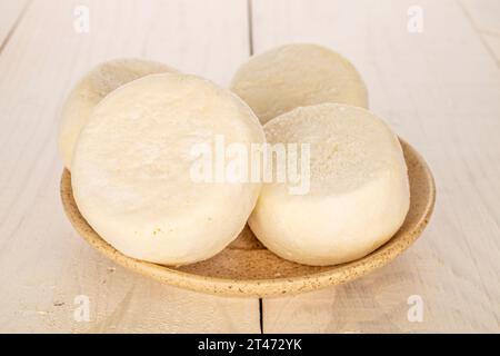 Plusieurs cheesecakes semi-finis congelés sur une soucoupe en céramique sur une table en bois, macro. Banque D'Images