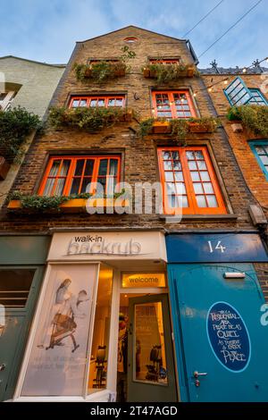 Londres, Royaume-Uni : Neal's Yard dans le quartier de Covent Garden au centre de Londres. Un immeuble résidentiel haut et étroit et une entreprise de massage. Banque D'Images