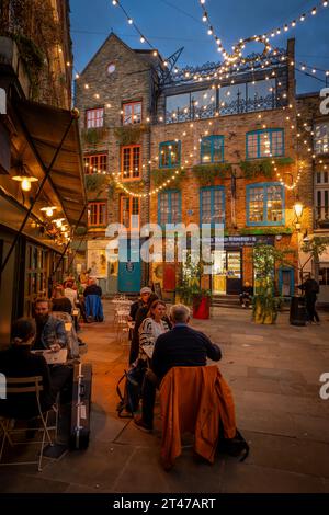 Londres, Royaume-Uni : Neal's Yard dans le quartier de Covent Garden au centre de Londres. Les gens assis à l'extérieur d'un restaurant le soir. Banque D'Images