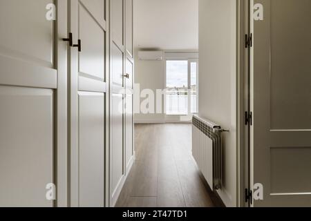 Couloir menant à une chambre avec une armoire sur mesure d'un côté Banque D'Images