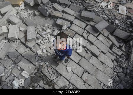 Al Bureij, Territoires palestiniens. 29 octobre 2023. Un enfant palestinien se tient debout sur les restes de bâtiments détruits autour de la mosquée Al-Bilal dans le camp Al-Bureij, à la suite des frappes aériennes israéliennes. Crédit : Mohammed Talatene/dpa/Alamy Live News Banque D'Images