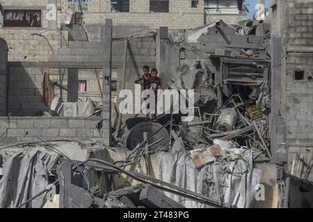 Al Bureij, Territoires palestiniens. 29 octobre 2023. Des enfants palestiniens se tiennent debout sur les restes de bâtiments détruits autour de la mosquée Al-Bilal dans le camp Al-Bureij, à la suite des frappes aériennes israéliennes. Crédit : Mohammed Talatene/dpa/Alamy Live News Banque D'Images