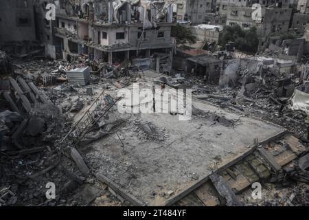 Al Bureij, Territoires palestiniens. 29 octobre 2023. Des enfants palestiniens marchent sur les restes de bâtiments détruits autour de la mosquée Al-Bilal dans le camp Al-Bureij, à la suite des frappes aériennes israéliennes. Crédit : Mohammed Talatene/dpa/Alamy Live News Banque D'Images