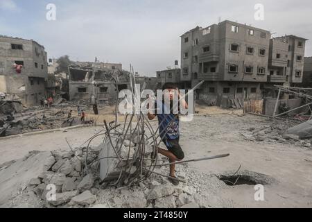 Al Bureij, Territoires palestiniens. 29 octobre 2023. Un enfant palestinien se tient debout sur les restes de bâtiments détruits autour de la mosquée Al-Bilal dans le camp Al-Bureij, à la suite des frappes aériennes israéliennes. Crédit : Mohammed Talatene/dpa/Alamy Live News Banque D'Images