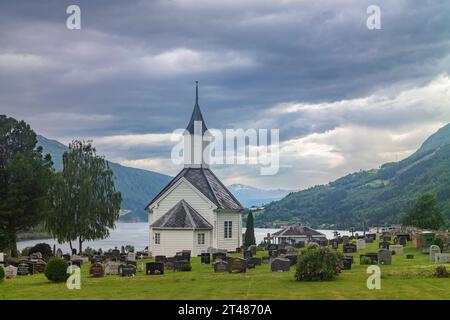 Loen, Norvège, 26 juin 2023 : l'église de Loen, une église paroissiale de l'église de Norvège, imaginée ici de l'arrière au cimetière, par une veille couverte Banque D'Images