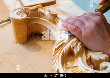 Une dame sculpte un rouleau en bois avec un ciseau Banque D'Images