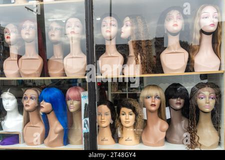 Une vitrine à Middlesbrough, Royaume-Uni présente des perruques sur des têtes de mannequin. Banque D'Images