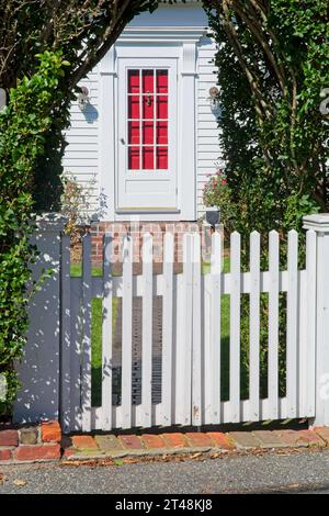 Barrière blanche de clôture de piquet sous l'entrée de la tonnelle de jardin naturelle au chalet traditionnel de morue du cap à Provincetown, Massachusetts — octobre 2023 Banque D'Images