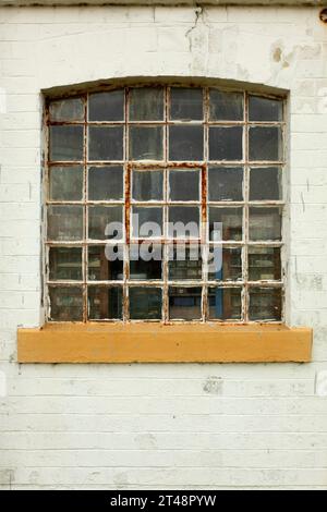 Vieille fenêtre rouillée à ossature métallique dans un bâtiment industriel. Banque D'Images