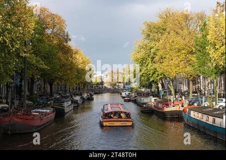 Amsterdam, pays-Bas. 29 octobre 2023. Superbes couleurs automnales sur les canaux d'Amsterdam. Un bateau touristique rondvaart parcourt les eaux. grachten, arbres, chute, herfst, toeristen, Boot, crédit : Imago/Alamy Live News Banque D'Images