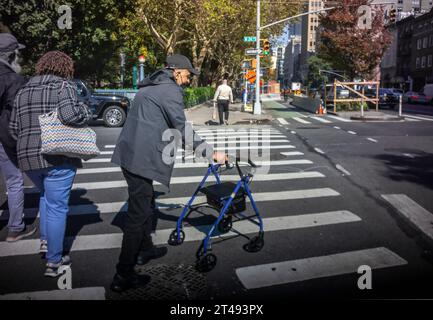 Un vieil homme avec marcheur traverse la rue à Chelsea à New York le jeudi 20 octobre 2023. (© Richard B. Levine) Banque D'Images