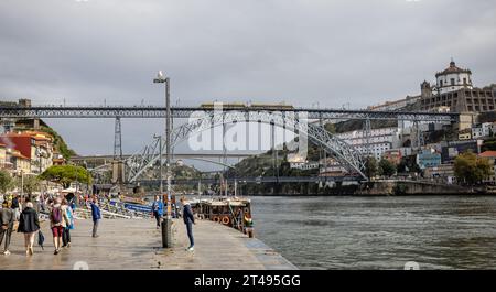 Train de métro traversant le pont Luis I sur le fleuve Douro vu du bord de la rivière à Porto, Portugal, le 18 octobre 2023 Banque D'Images