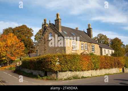 Vue sur le village de Hartington dans le district de Derbyshire Peak avec une vue sur l'église Saint Giles et les chalets de campagne en automne Banque D'Images