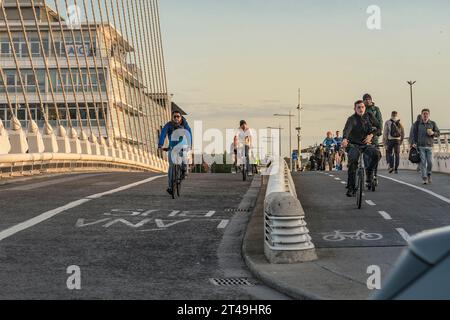 Aller au travail à vélo. Cyclistes traversant la rivière Liffey par Samuel Beckett Bridge sans voitures. Dublin. Irlande. Banque D'Images