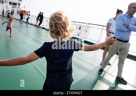 Les enfants jouent dans le vent sur le pont d'un ferry de croisière de la mer Baltique voyageant entre Helsinki en Finlande, Åland et Stockholm en Suède. Banque D'Images