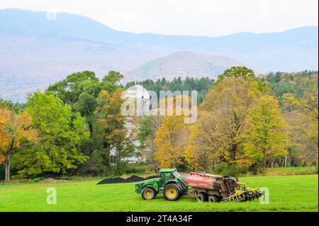 Tracteur et équipement agricole travaillant sur un champ d'automne vert dans les Green Mountains du Vermont. Banque D'Images