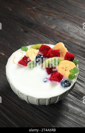 Yaourt avec garniture aux fruits frais Barious, fruit du dragon, banane, kiwi et myrtille. Banque D'Images