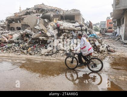 Le Dr Hassan Zein Al-DIN fait du vélo à l'intérieur d'une école des Nations Unies pour soigner les personnes déplacées par la guerre dans le camp d'Al-Bureij, dans le centre de la bande de Gaza. Palestinien Dr Hassan Zein al-DIN, 54 ans, spécialiste de la médecine générale et des maladies chroniques. Il a été déplacé de la ville de Gaza vers la région de Bureij en raison de la guerre. Il se déplace à vélo entre les centres d’accueil pour soigner les déplacés et assurer le suivi de leurs cas au quotidien. Il se rend dans la ville de Gaza pour suivre les cas d’un certain nombre de patients dans les centres d’hébergement laissés par l’administration de l’UNRWA. À cause de l'ISR Banque D'Images