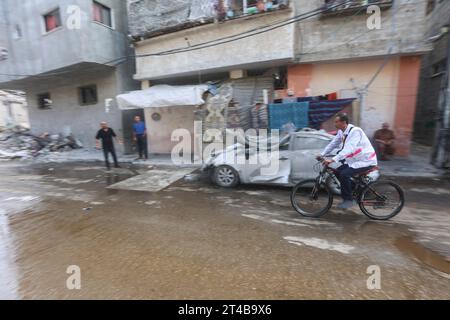 Le Dr Hassan Zein Al-DIN fait du vélo à l'intérieur d'une école des Nations Unies pour soigner les personnes déplacées par la guerre dans le camp d'Al-Bureij, dans le centre de la bande de Gaza. Palestinien Dr Hassan Zein al-DIN, 54 ans, spécialiste de la médecine générale et des maladies chroniques. Il a été déplacé de la ville de Gaza vers la région de Bureij en raison de la guerre. Il se déplace à vélo entre les centres d’accueil pour soigner les déplacés et assurer le suivi de leurs cas au quotidien. Il se rend dans la ville de Gaza pour suivre les cas d’un certain nombre de patients dans les centres d’hébergement laissés par l’administration de l’UNRWA. À cause de l'ISR Banque D'Images