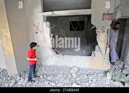 Naplouse. 29 octobre 2023. Des gens inspectent une maison endommagée après un raid militaire israélien dans un camp de réfugiés près de la ville de Naplouse en Cisjordanie le 29 octobre 2023. En 23 jours, au moins 8 005 Palestiniens, dont 3 342 enfants, 2 062 femmes et 460 personnes âgées, ont perdu la vie dans les frappes aériennes israéliennes, selon les autorités sanitaires palestiniennes à Gaza. Crédit : Ayman Nobani/Xinhua/Alamy Live News Banque D'Images