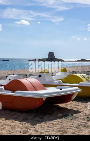 Pédalos sur la plage en face de la Torre di Bari Sardo, tour de guet espagnole historique du 16e siècle, Bari Sardo, Ogliastra, Sardaigne, Italie Banque D'Images