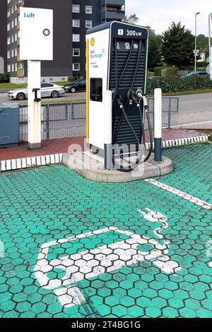 Station de charge de Shell avec une puissance de 300 kw pour les voitures électriques en face de lui parking pavé vert marqué avec symbole pour voiture électrique, Allemagne Banque D'Images