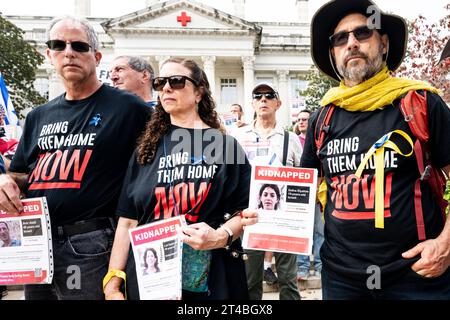 Washington, États-Unis. 29 octobre 2023. Personnes portant des pancartes lors d'un rassemblement pour ramener à la maison des otages enlevés par le Hamas en Israël le 7 octobre 2023 et détenus à Gaza. Rassemblement devant le siège national de la Croix-Rouge américaine à Washington, DC. (Photo de Michael Brochstein/Sipa USA) crédit : SIPA USA/Alamy Live News Banque D'Images