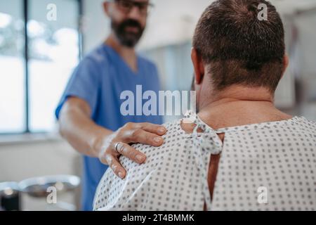 Médecin de soutien apaisant un patient inquiet en surpoids, discutant du résultat du test à la salle d'urgence. Maladies et maladies de la santé de l'homme d'âge moyen Banque D'Images