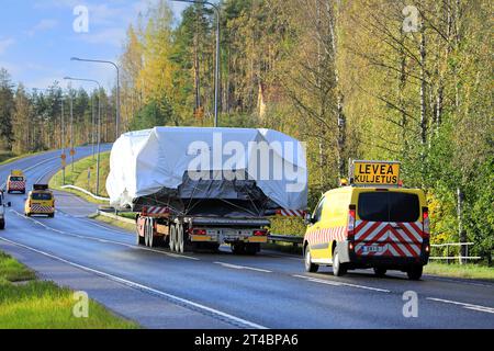 Rouge Volvo FH camion remorque à plateau M Nikkanen Ky transporte une large charge. Le transport dispose de 3 véhicules pilotes à l'avant et à l'arrière. Raasepori, Finlande. 13 octobre 23 Banque D'Images