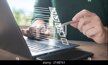 Concept de gestion des documents. Homme d'affaires utilisant un ordinateur portable et touchant au papier électronique en ligne pour approuver. Liste de contrôle électronique SMART et doc Banque D'Images