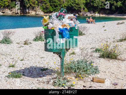 Poubelles trop remplies sur une plage propre sur la côte nord-est de Corfou Grèce Banque D'Images