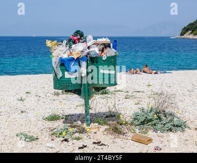 Poubelles trop remplies sur une plage propre sur la côte nord-est de Corfou Grèce Banque D'Images