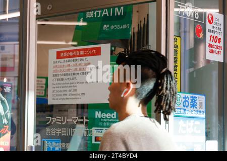 Tokyo, Japon. 30 octobre 2023. Un homme passe devant une pancarte affichant un message interdisant la vente d'alcool pendant les célébrations d'Halloween à Shibuya. Les autorités de Shibuya affichent des pancartes autour de la zone commerçante de Shibuya, avertissant les gens de ne pas se rassembler dans les rues pendant la saison d'Halloween. (Image de crédit : © Rodrigo Reyes Marin/ZUMA Press Wire) USAGE ÉDITORIAL SEULEMENT! Non destiné à UN USAGE commercial ! Crédit : ZUMA Press, Inc./Alamy Live News crédit : ZUMA Press, Inc./Alamy Live News Banque D'Images