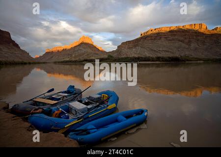 Les radeaux sont ancrés au rivage du fleuve Colorado alors que le soleil se couche sur les sommets derrière, le parc national de Canyonlands, Utah. Banque D'Images