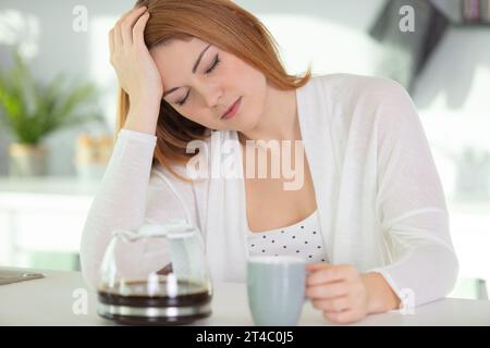 femme très fatiguée regardant tôt le matin buvant du café Banque D'Images