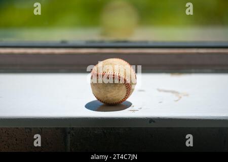 Vieille balle de baseball se trouvant sur le rebord de la fenêtre sale avec espace de copie Banque D'Images