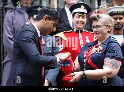 Londres, Royaume-Uni. 31 octobre 2023. Les collectes de fonds de la Légion britannique ont visité le numéro 10. Downing Street pour que le PM Rishi Sunak puisse chasser un coquelicot, avec sa femme Akshata Murty pour le Poppy Appeal de cette année. C’est la première année que des coquelicots sans plastique et entièrement recyclables sont produits. Crédit : Monica Wells/Alamy Live News Banque D'Images