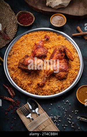 Plat de riz Mandi avec viande de poulet grillée et épices sur fond vert foncé Banque D'Images