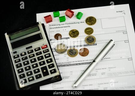 Document sur l'impôt foncier avec maisons, stylo à bille, calculatrice et euros Banque D'Images