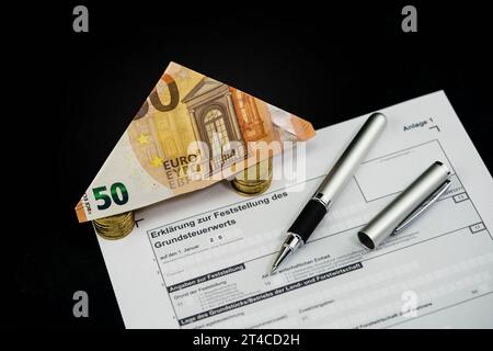 Document sur la taxe foncière avec billet plié de 50 euros et stylo à bille Banque D'Images