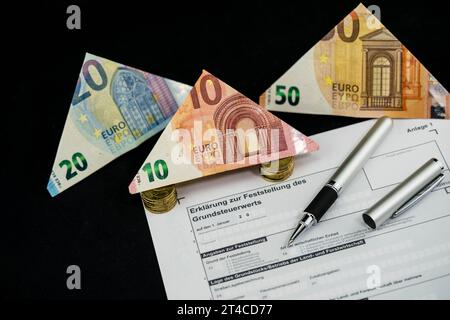 Document sur la taxe foncière avec billets en euros pliés et stylo à bille Banque D'Images