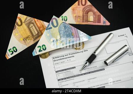 Document sur la taxe foncière avec billets en euros pliés et stylo à bille Banque D'Images