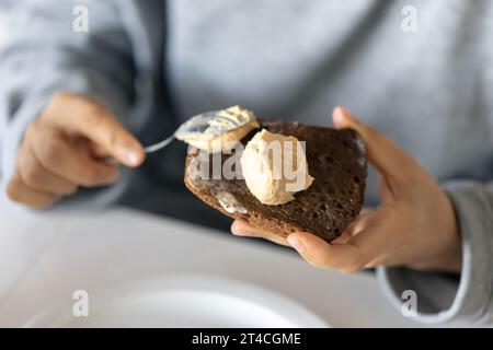 Femme étalant du pain, gros plan, concept de petit déjeuner. Banque D'Images