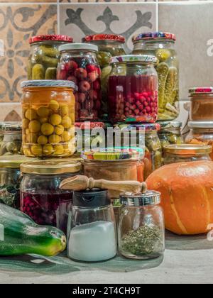 Confitures de fruits et légumes assorties dans des bocaux empilés sur la table de cuisine Banque D'Images